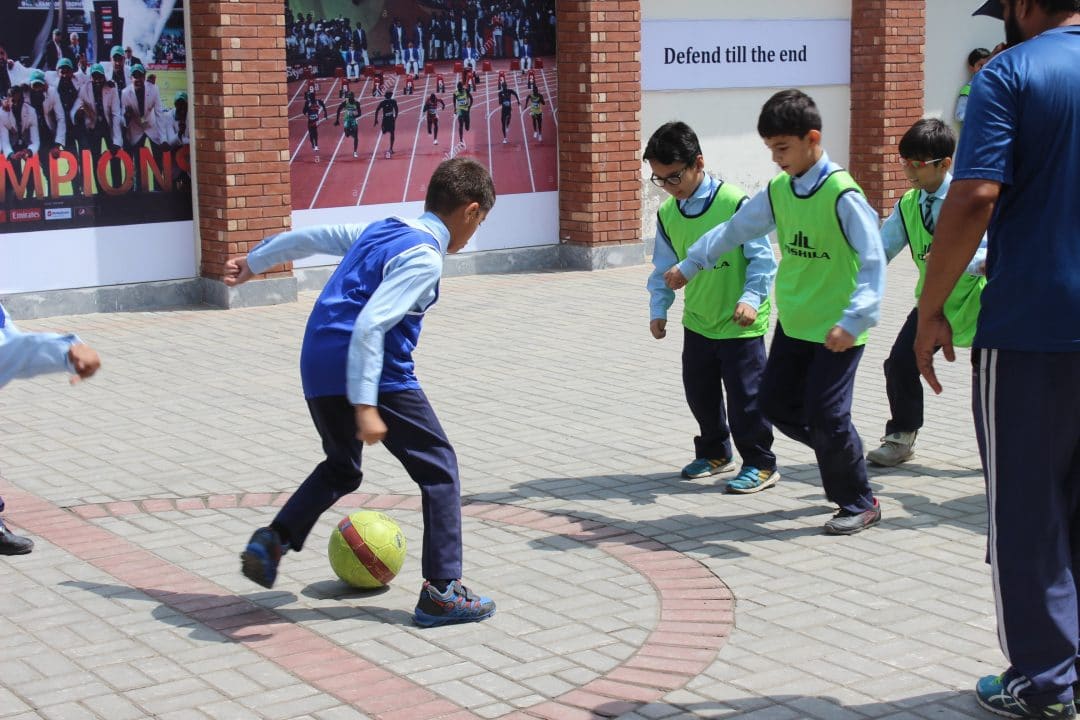 Boys playing football in the school courtyard